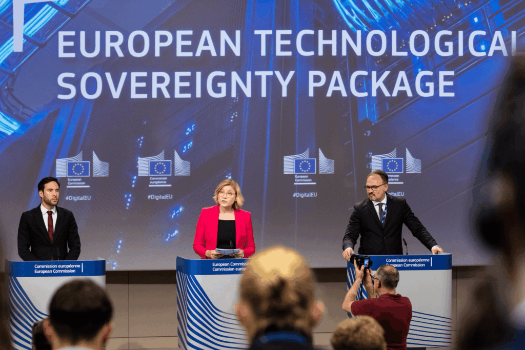 A vice-presidente executiva Henna Virkkunen fala em uma coletiva de imprensa da Comissão Europeia sobre o Pacote Europeu para a Soberania Tecnológica, ao lado do comissário Dan Jørgensen e do porta-voz Thomas Regnier em um pódio, com jornalistas e fotógrafos presentes